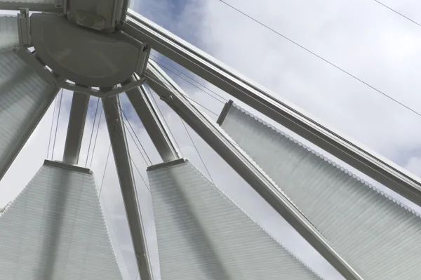 Close up of pale grey conservatory roof blinds on a partially domed conservatory roof, at varying height levels to the inner meeting point.