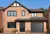 Contemporary house with apex window and integral garage with black roller garage door that matches the black front door and red block paving driveway.