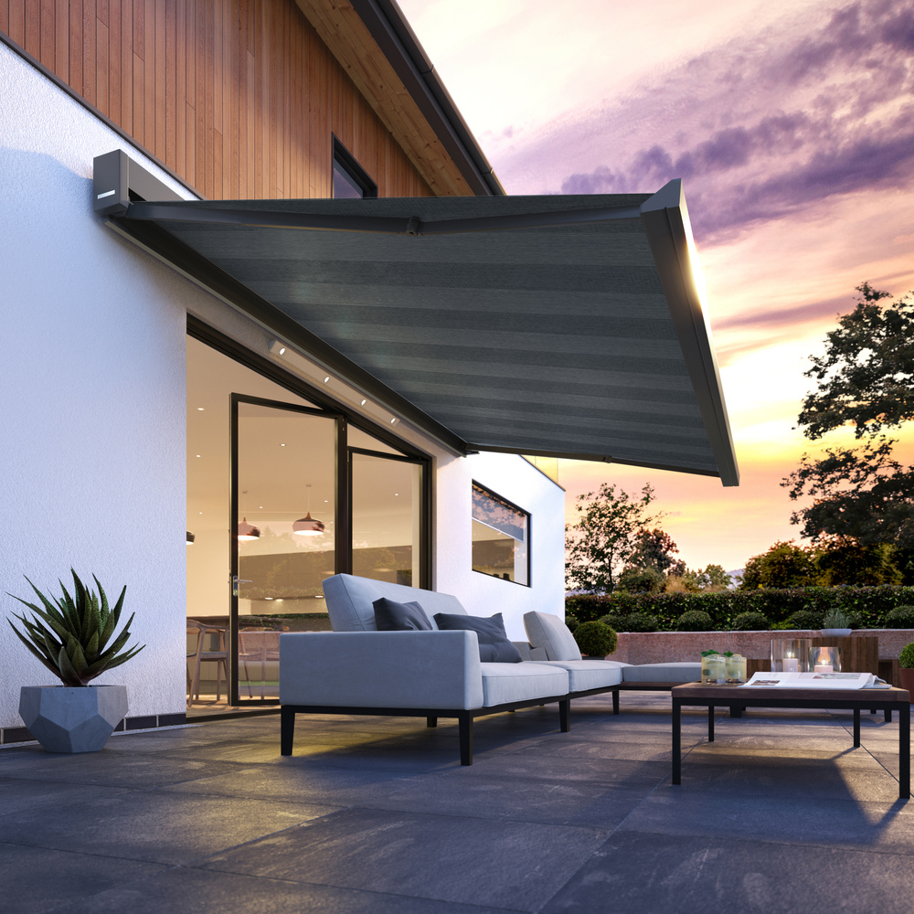 dark grey awning over modern outdoor furniture and bifold doors infront of a picturesque sky