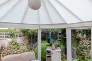 Round conservatory with roof blinds only in white.