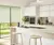 Kitchen in white with touches of green and bifold doors dressed in pale green roller blinds.