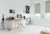 Large home office in white with  two windows dressed in roller blinds in pale green, black and yellow waterfall pattern, modern wood desk and chair, iMac and black desk accessories, tall cactus in concrete pot on floor by copper wirework bin.