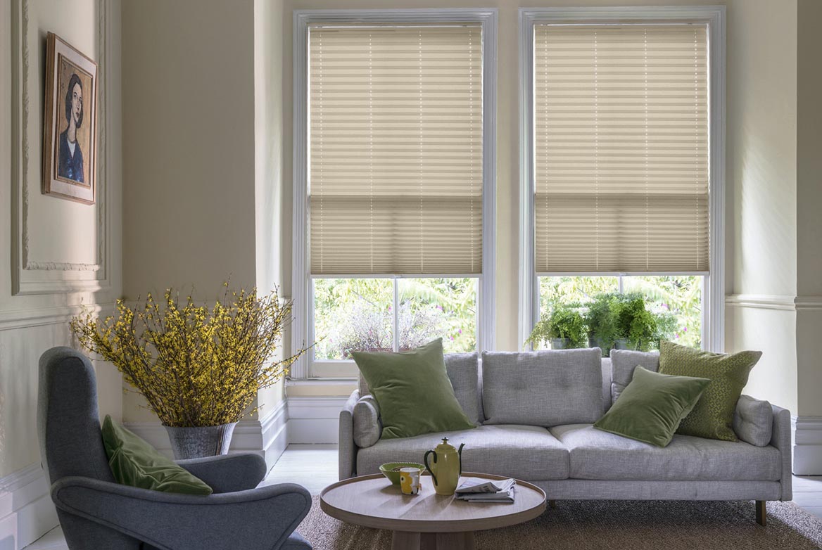 Fitted to multiple windows in a marble and white decorated kitchen are Mara Biscotti Pleated blind. The plain design of these natural Pleated blinds completes the look.