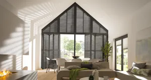 black tier on tier shutters fitted to a gable end window in an open plan living room and dining room