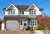 Modern two tone white and brick house with integral garage with olive green roller garage door matching the front door.
