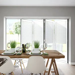 White coloured pleated blinds that are fitted to bifold doors in a dining room that is decorated in white and wood textures