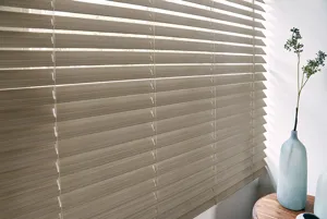 Close up of pale wood venetian blind, lowered with slats slightly tilted.