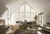 Lounge with feature stone fireplace to left, contemporary sofas, dining table and chairs behind with gable end window and doors to rear dressed in white shutters, louvres open.