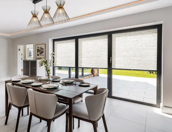 Scandia Hus Naturelle Stone Ochre Duette Pleated blind fitted to multiple door windows in a dining room