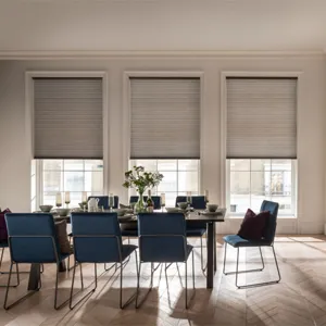 grey duette blinds fitted to three windows in a dining room