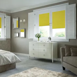 Yellow pleated blinds matched with white shutters on rectangular shaped windows in a bedroom decorated in grey and beige tones