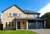 Yellow Cotswold stone-style house with integral  garage with two blue steel garage doors that match the front door.