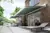 Side shot of house with two steel blue awnings extended over patio with furniture underneath.